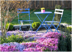 Twee stoelen in tuin vol bloemen